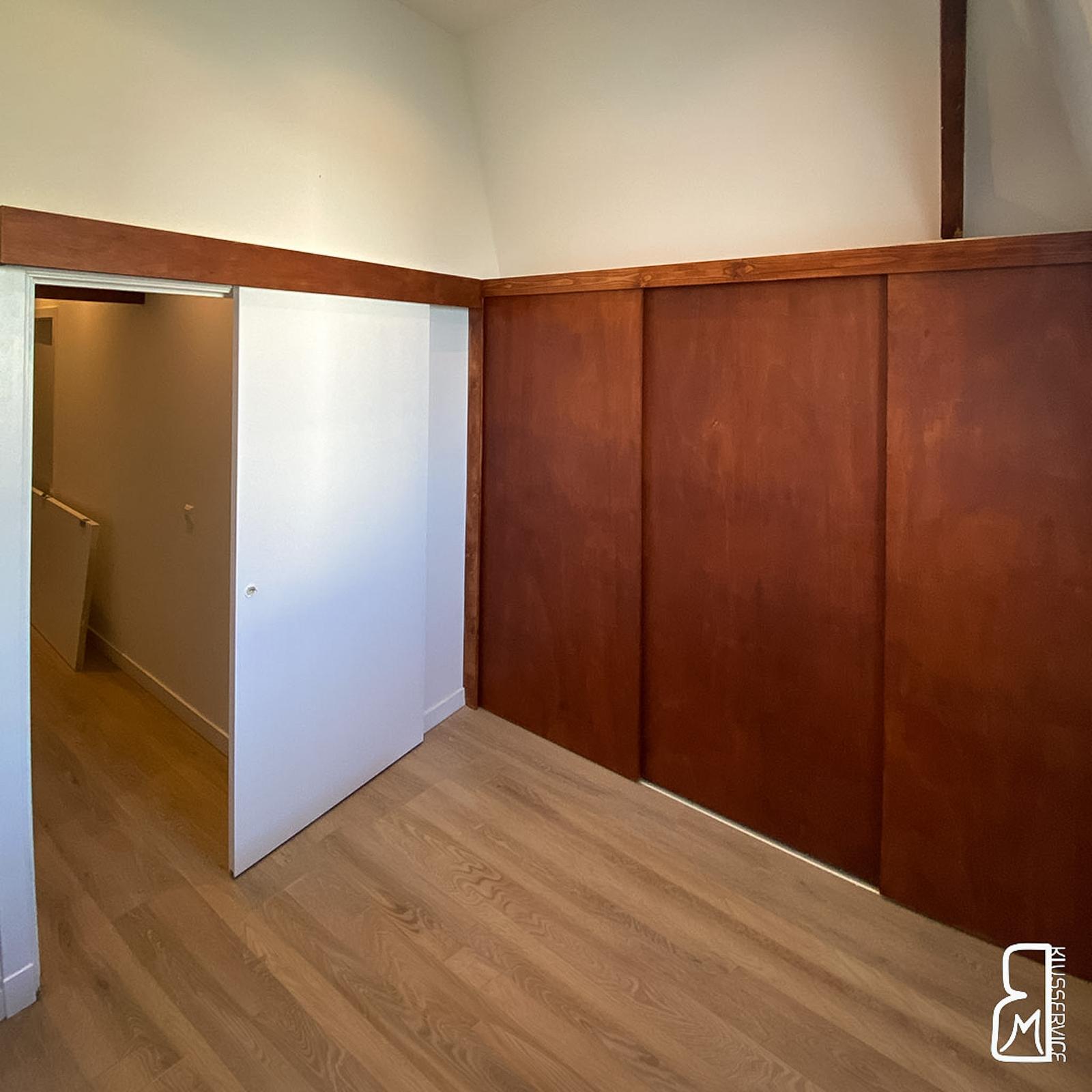 Teak attic closet with sliding door beside the room entrance
